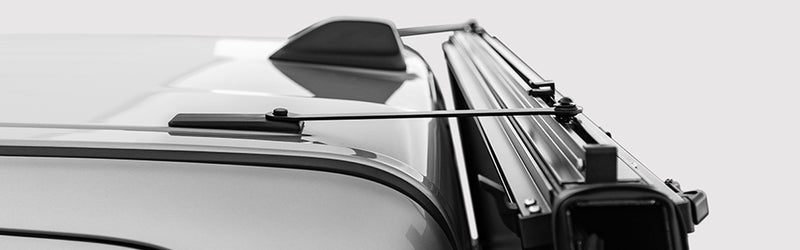 LOMAX STANCE tonneau cover: black-and-white wide detail of the STANCE magnetic support brace running from the cab roof to the vertically folded panel frame