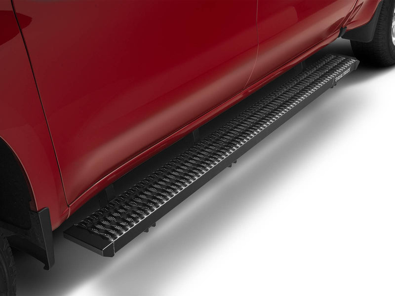 Low view along a red crew-cab pickup showing a full-length N-Fab Growler Fleet grip-plate side step in textured black