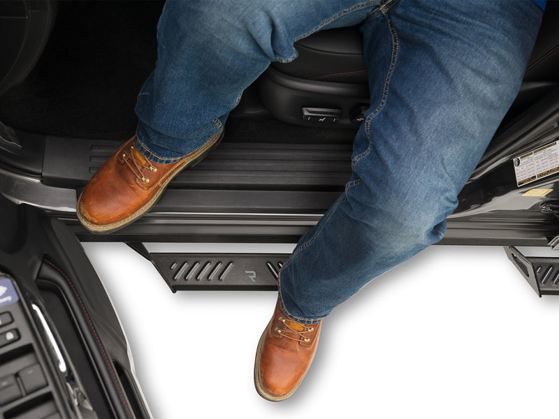 N-Fab Predator Pro nerf steps in textured black, boot on the step at an open door, on a Toyota 4Runner