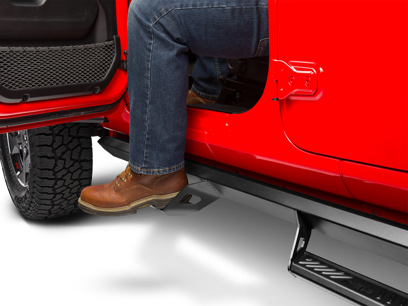 N-Fab Predator Pro nerf steps in textured black, boot on the step at an open door, on a Jeep Gladiator