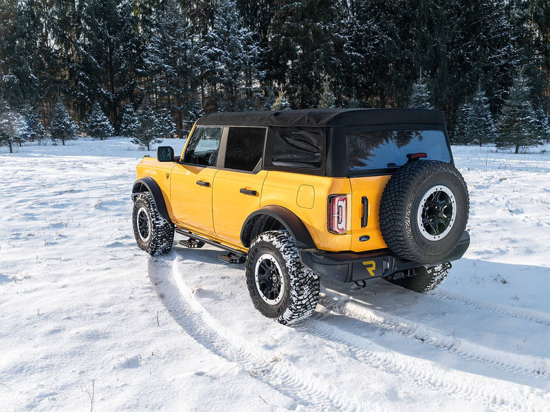 N-Fab RKR Step System in textured black, rear three-quarter view, installed along the rocker in snow