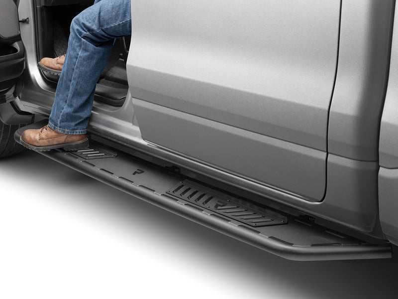 N-Fab Roan running boards in textured black, boot on the step at an open door, on a Ram 1500