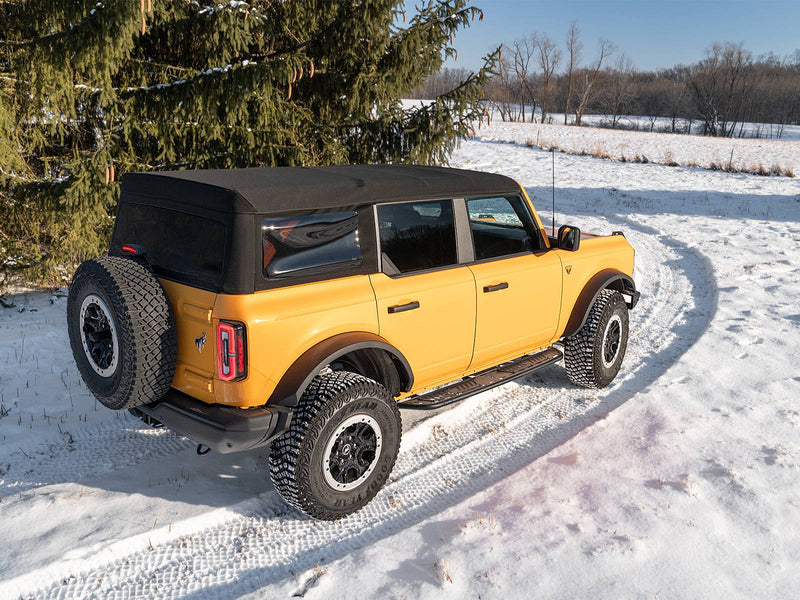 N-Fab Roan running boards in textured black, rear three-quarter view, installed along the rocker in snow