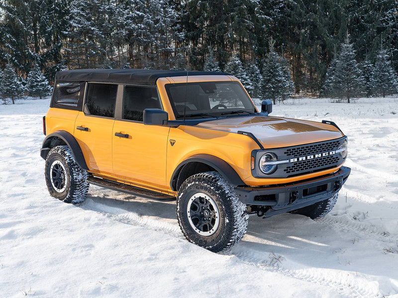 N-Fab Roan running boards in textured black, front three-quarter view, installed along the rocker in snow
