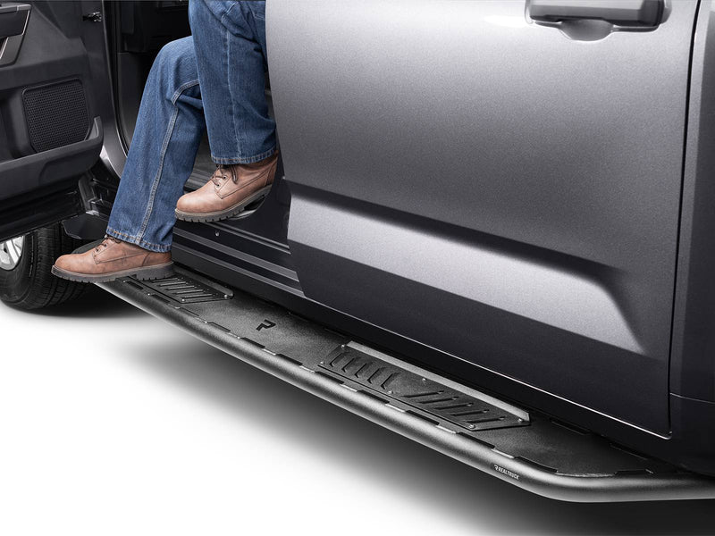 N-Fab Roan running boards in textured black, boot on the step at an open door