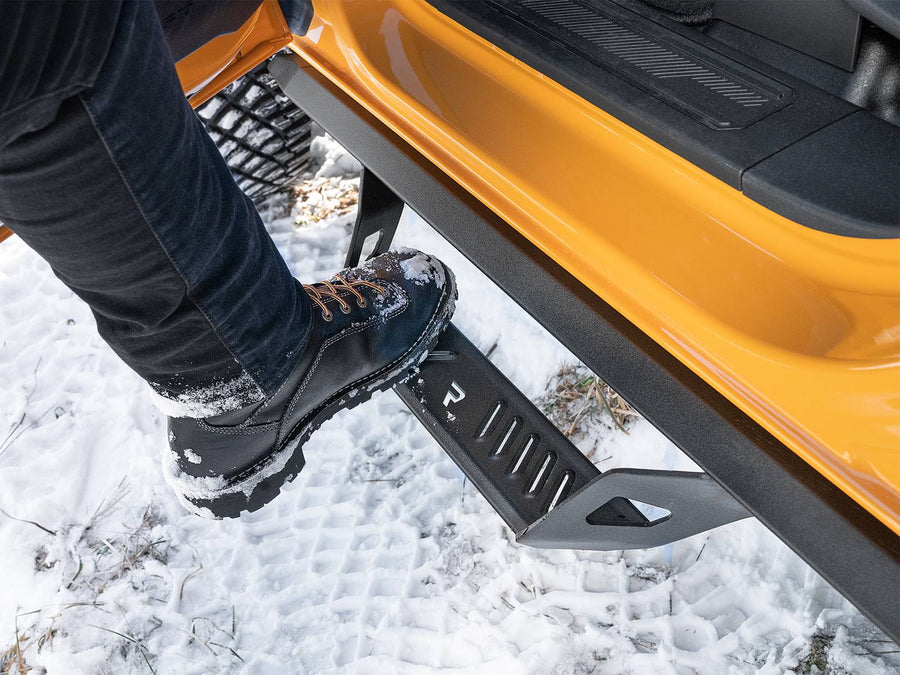 N-Fab Predator Pro nerf steps in textured black, boot on the step at an open door