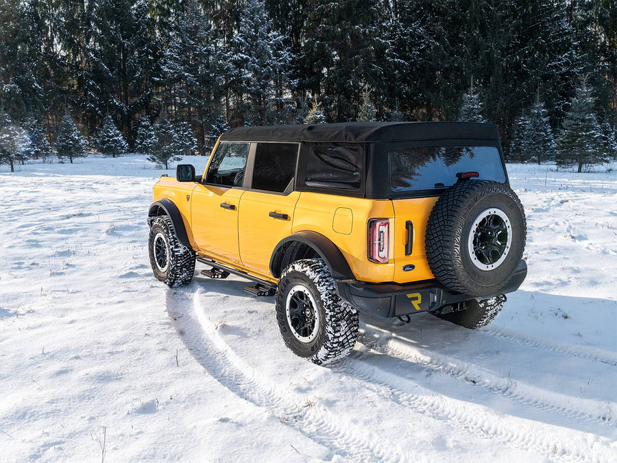 N-Fab RKR Step System in textured black, rear three-quarter view, installed along the rocker in snow