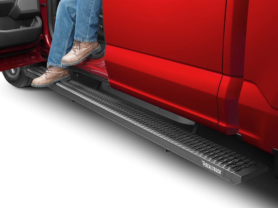N-Fab Growler Fleet side steps in textured black, boot on the step at an open door