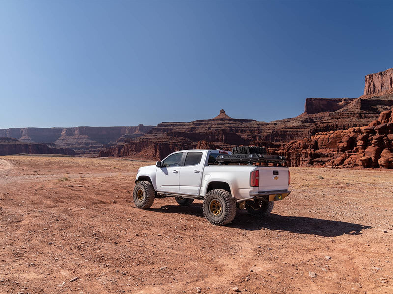 N-Fab TrailSlider step system in textured black, installed, shown with a bed rack and a rear bumper (not included), on a Chevrolet Colorado ZR2