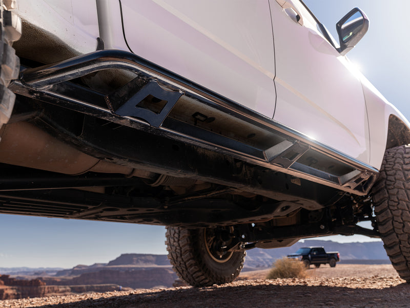 N-Fab TrailSlider step system in textured black, installed along the rocker among red rock cliffs, on a Chevrolet Colorado ZR2