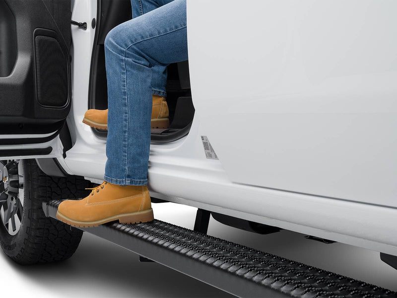 Work boots stepping onto a N-Fab Growler Fleet grip-plate side step at an open white door