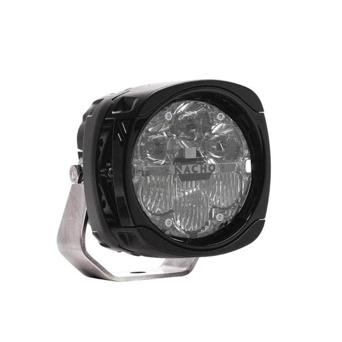 NACHO Quatro SAE LED auxiliary light at an angle, squared black housing with a clear lens over four round reflectors and a lower fog optic section, SAE and DOT compliance markings etched into the lens beside the NACHO lettering