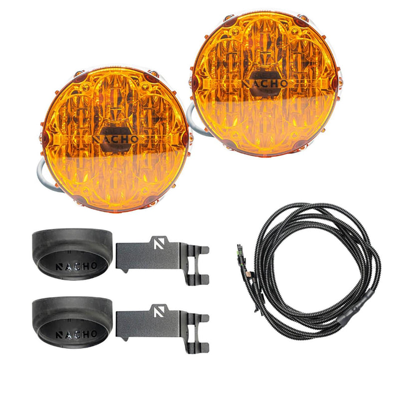 NACHO plug and play fog light kit contents on white: two amber-lens Quatro SAE round lights, two black NACHO branded silicone filler cones, two angled steel mounting brackets and a coiled loomed harness