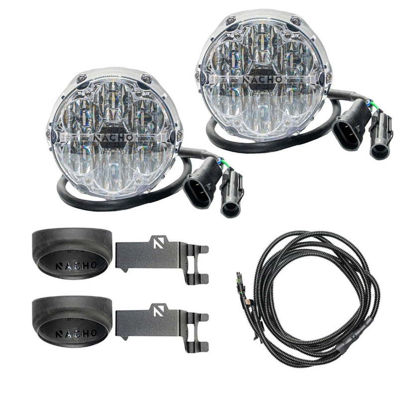 NACHO plug and play fog light kit contents on white: two clear-lens Quatro SAE round lights, two black silicone filler cones with NACHO branding, two angled steel mounting brackets and a coiled loomed harness