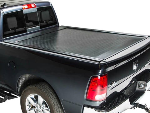 Pace Edwards BedLocker: black retractable cover fully closed on a black pickup bed, rear three-quarter studio view