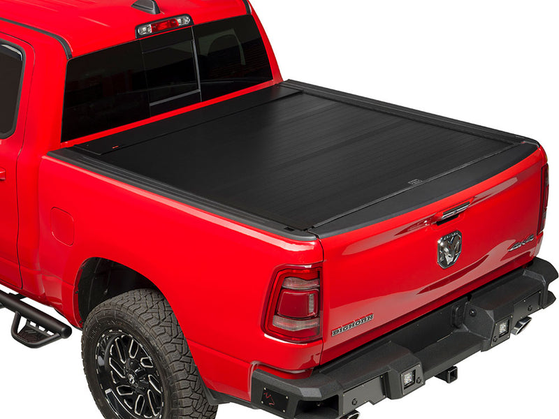 Pace Edwards BedLocker: black retractable cover fully closed on a red pickup bed, tailgate up, rear three-quarter view