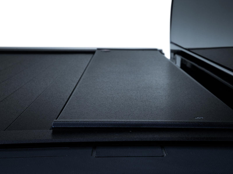 Pace Edwards BedLocker: close-up of the black canister lid where the closed slatted cover meets the front of the bed