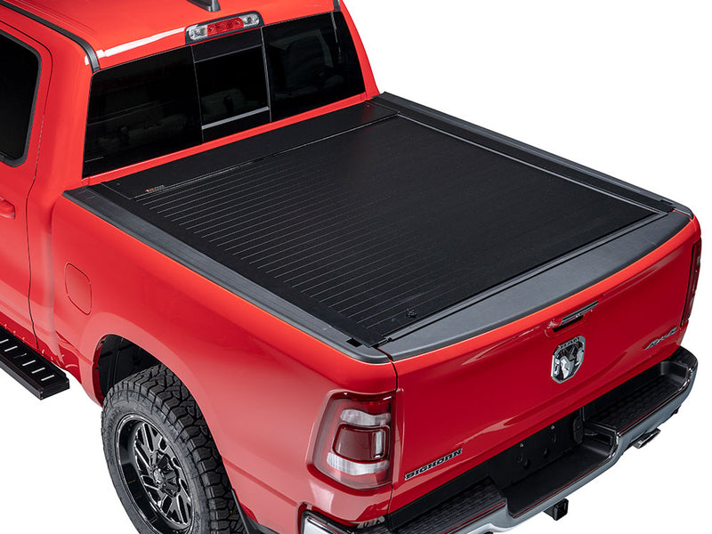 Pace Edwards Full Metal JackRabbit: black retractable cover fully closed on a red pickup bed, rear three-quarter view