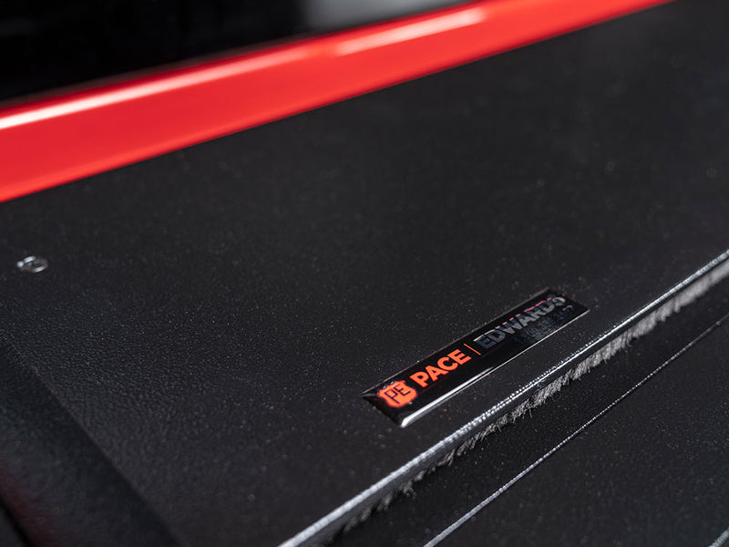 Pace Edwards Full Metal JackRabbit: close-up of the black canister lid with a Pace Edwards badge, red bed rail behind