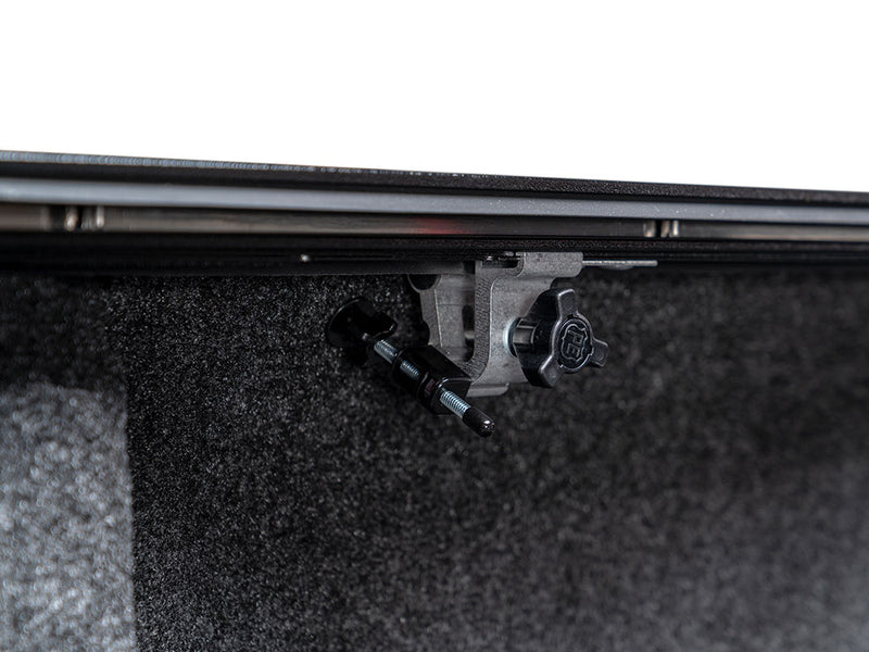 Pace Edwards Full Metal JackRabbit: rail clamp bolted beneath the side rail inside a carpet-lined truck bed