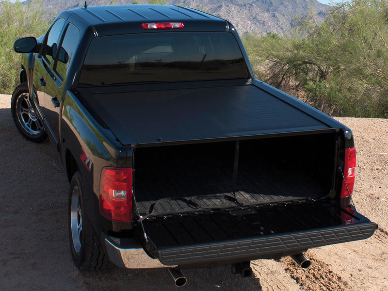 Pace Edwards JackRabbit: black retractable cover fully closed on a black pickup, tailgate down, desert hillside