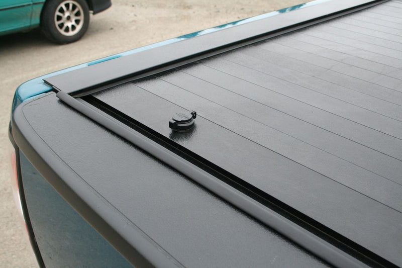 Pace Edwards JackRabbit: close view of a closed black retractable cover showing the tailgate-end lock and side rail