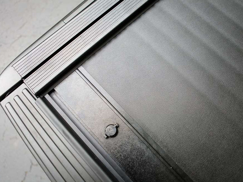 Pace Edwards JackRabbit: close view of the textured vinyl-covered slats, tailgate-end lock and ribbed side rail of a closed cover