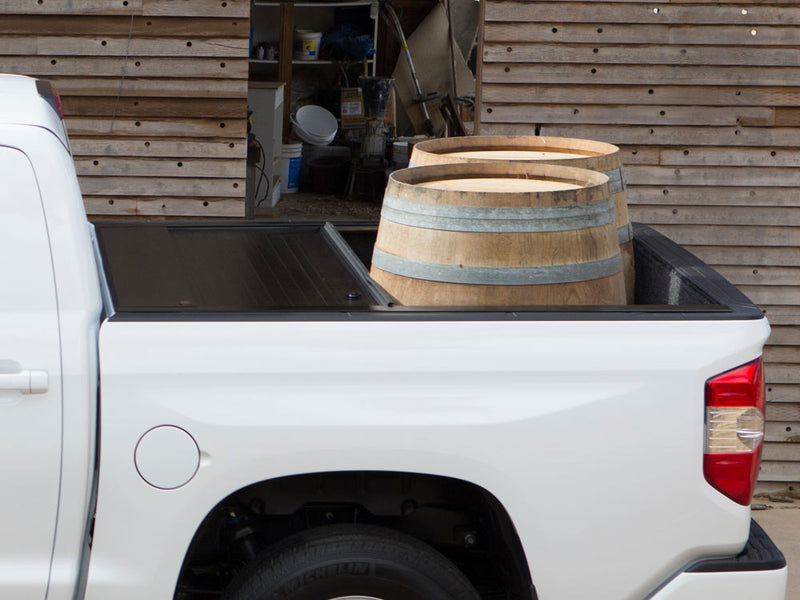 Pace Edwards JackRabbit: retractable cover partly open on a white pickup with two wine barrels in the exposed bed