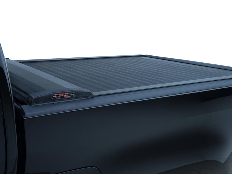 Pace Edwards SwitchBlade: black retractable tonneau cover fully closed on a black truck bed, canister with Pace Edwards end cap, white background