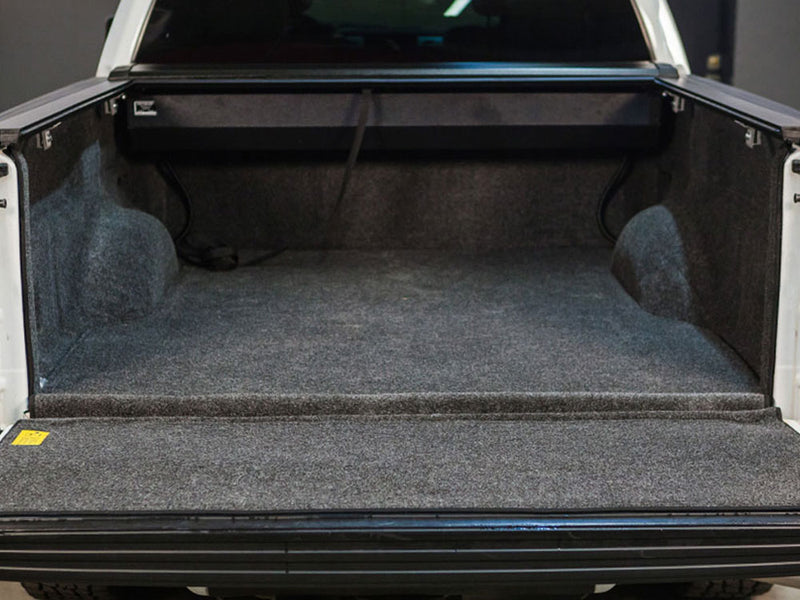 Pace Edwards SwitchBlade: rear view into an open truck bed with the retractable cover fully rolled into its front canister, carpeted bed liner