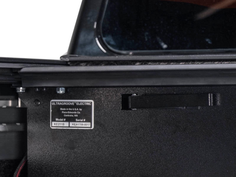 Pace Edwards UltraGroove Electric: black canister side with an UltraGroove Electric model and serial label inside a truck bed