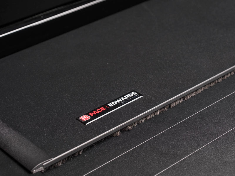 Pace Edwards UltraGroove Electric: close view of the Pace Edwards badge on a closed matte black slatted cover