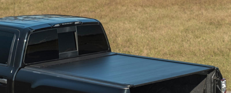 Pace Edwards UltraGroove Electric: matte black cover closed on a black pickup, tailgate down, rear three-quarter view