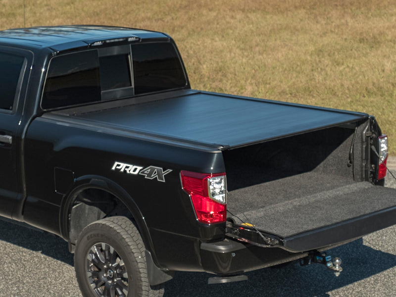 Pace Edwards UltraGroove Electric: matte black cover closed on a black pickup, tailgate down, rear three-quarter view (closed)