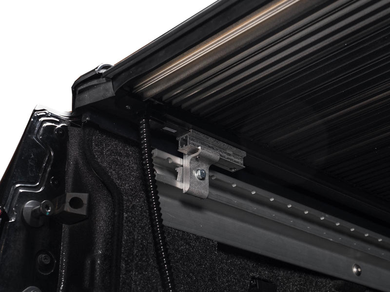 Pace Edwards UltraGroove Electric: underside view of side rail, mounting bracket and drain hose below partly retracted slats