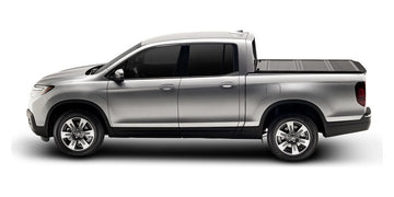 Silver 2017 Honda Ridgeline fitted with an UnderCover Flex hard folding cover