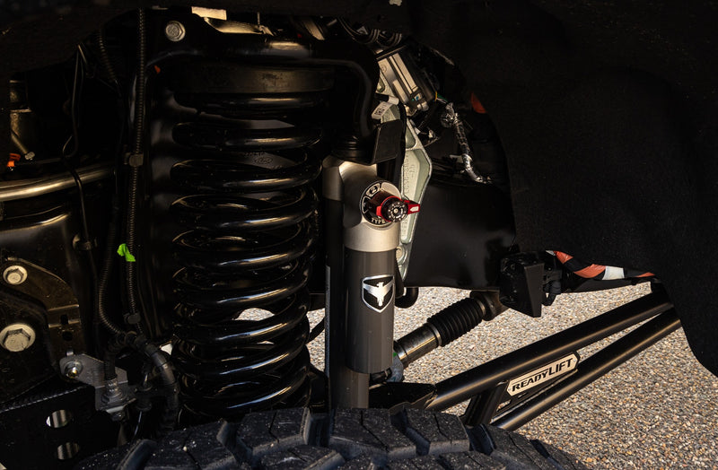 ReadyLIFT Coil Spring Suspension System on a vehicle: black coil spring, Falcon shock and ReadyLIFT radius arm installed in a Super Duty front end
