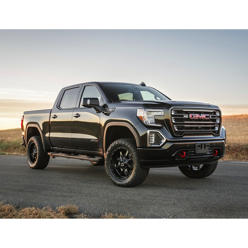 ReadyLIFT Leveling Kit installed on a GMC Sierra 1500 AT4: black GMC Sierra 1500 AT4 crew cab leveled on black wheels on a road at sunset