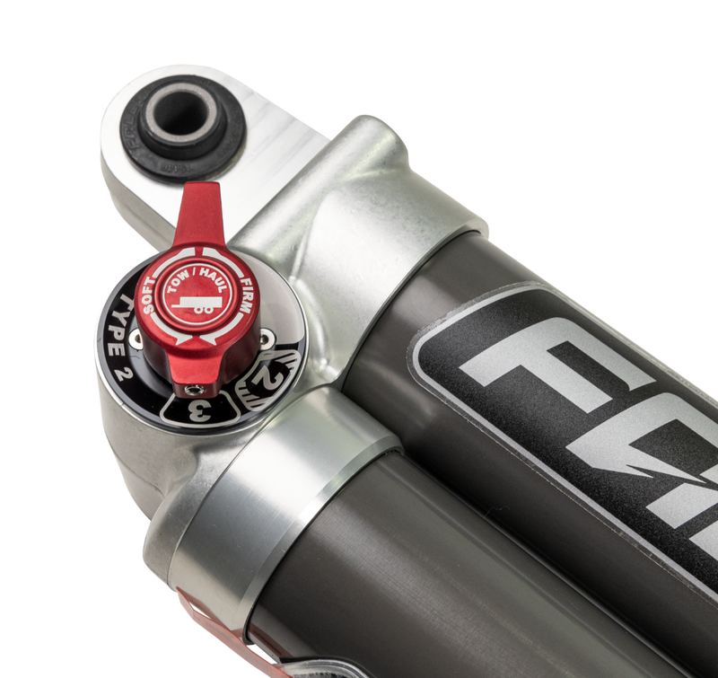 Close-up of the ReadyLIFT Lift Kit: close-up of a Falcon shock red tow/haul adjuster dial on a black background