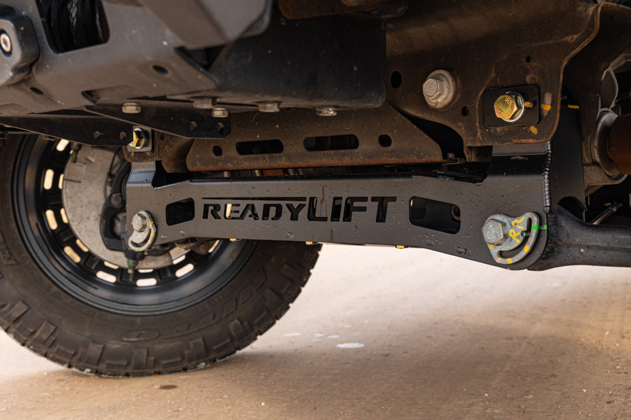 ReadyLIFT MAX3.3 Suspension System on a vehicle: ReadyLIFT-stamped front crossmember installed under a truck behind the front tire