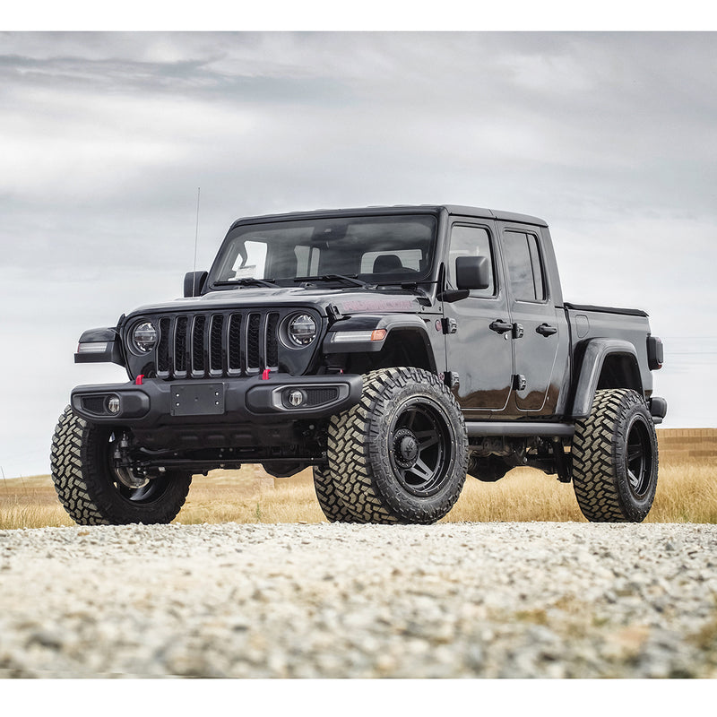 ReadyLIFT SST Lift Kit installed on a Jeep Gladiator: A black lifted Jeep Gladiator parked on gravel under an overcast sky