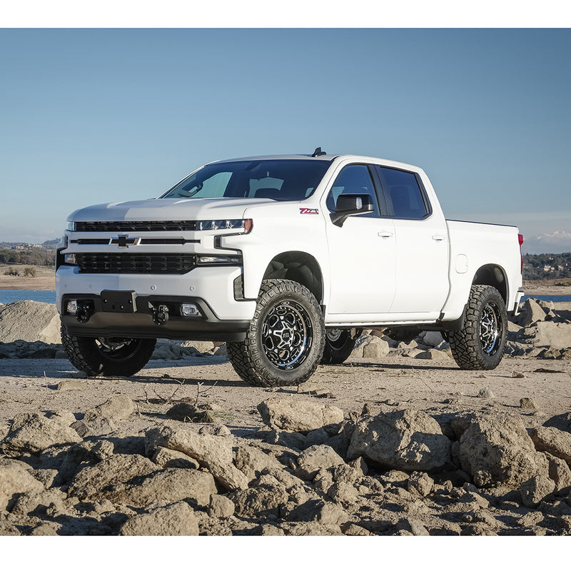 ReadyLIFT SST Lift Kit installed on a Chevrolet Silverado 1500: A white lifted Chevrolet Silverado 1500 Z71 Crew Cab parked on rocks by a lake