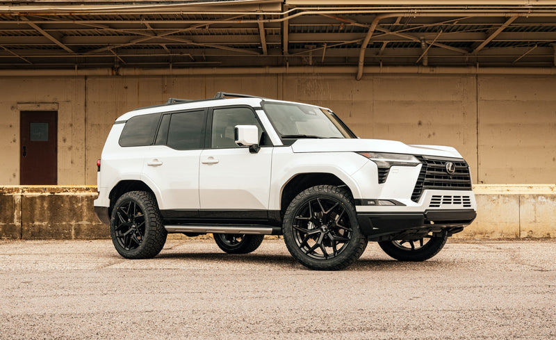 ReadyLIFT SST Lift Kit installed on a Lexus GX550: A white lifted Lexus GX550 parked in front of a loading dock