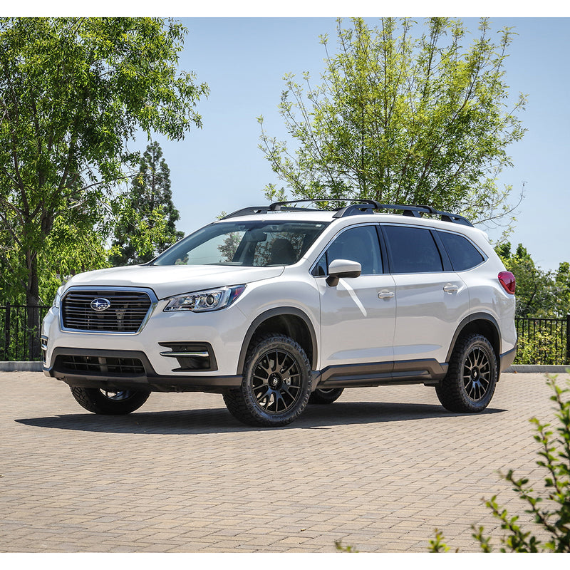 ReadyLIFT SST Lift Kit installed on a Subaru Ascent: A white lifted Subaru Ascent parked on pavers with trees behind