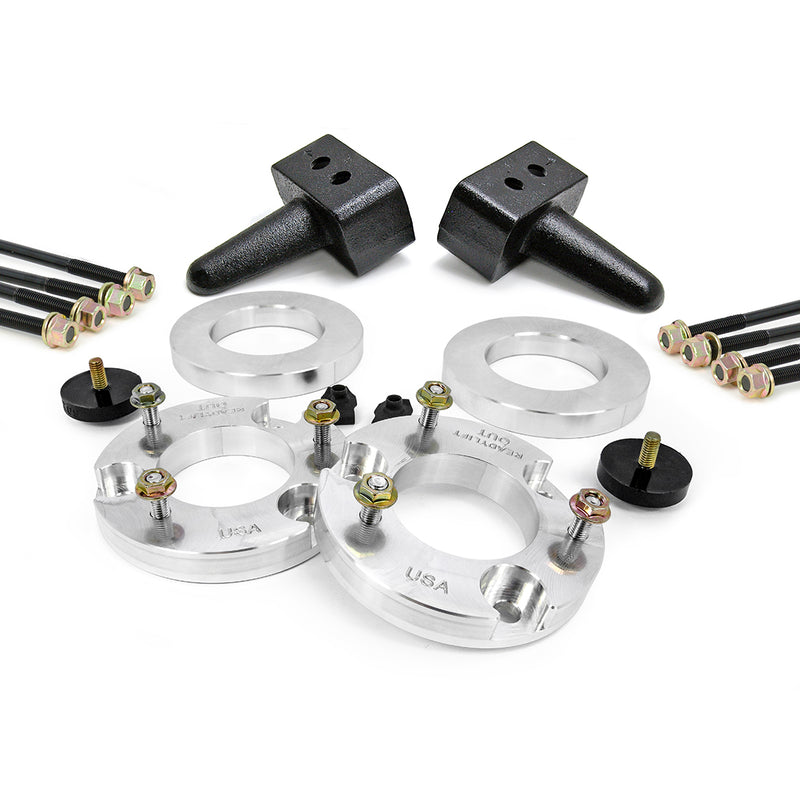 ReadyLIFT SST Lift Kit, full kit on a studio background: aluminum strut spacers, two tapered rear blocks, U-bolts and bump stops on white