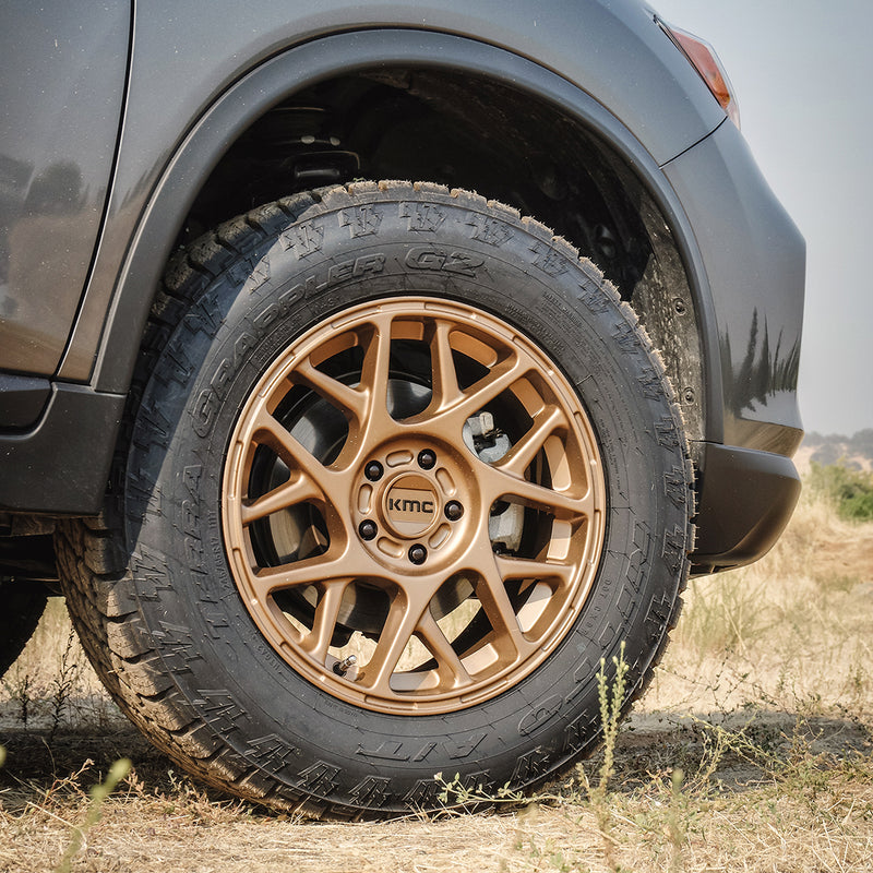 ReadyLIFT SST Lift Kit on a Nissan Rogue: close-up of a lifted gray Nissan Rogue front wheel with a bronze KMC wheel and all-terrain tire