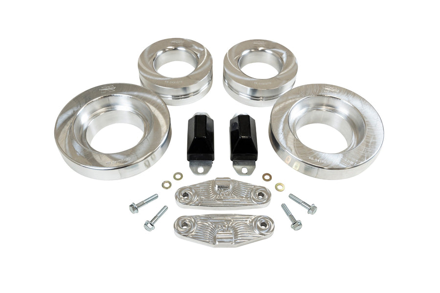 ReadyLIFT SST Lift Kit, full kit on a studio background: four aluminum coil spacers, two black bump stops, two aluminum brackets and bolts on white