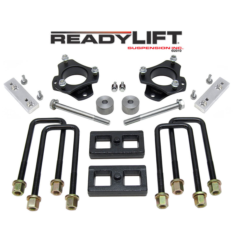 ReadyLIFT SST Lift Kit, full kit on a studio background: two black strut spacers, aluminum brackets, two flat rear blocks and U-bolts under a ReadyLIFT logo