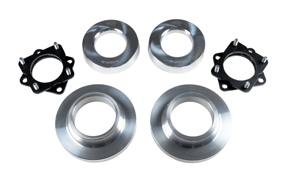 ReadyLIFT SST Lift Kit, full kit on a studio background: two black strut spacers and four aluminum coil spacers on a black-bordered white strip