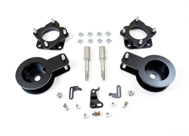 ReadyLIFT SST Lift Kit, full kit on a studio background: two black strut spacers, two black rear spacer cups, pins, brackets and hardware on white